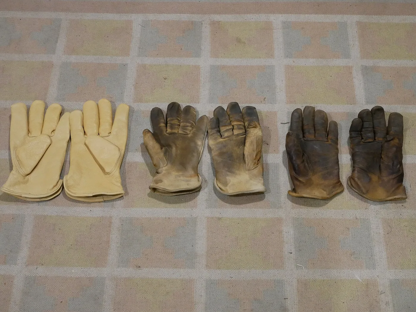 Trois paires de gants de travail en cuir, neuve, usagée et très usée