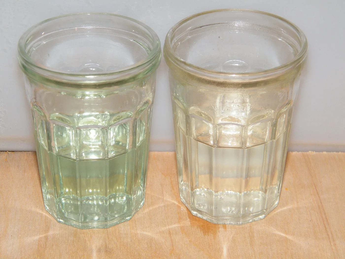 Deux verres d'essence : à gauche mélange 2 temps à 2 %, à droite essence pure