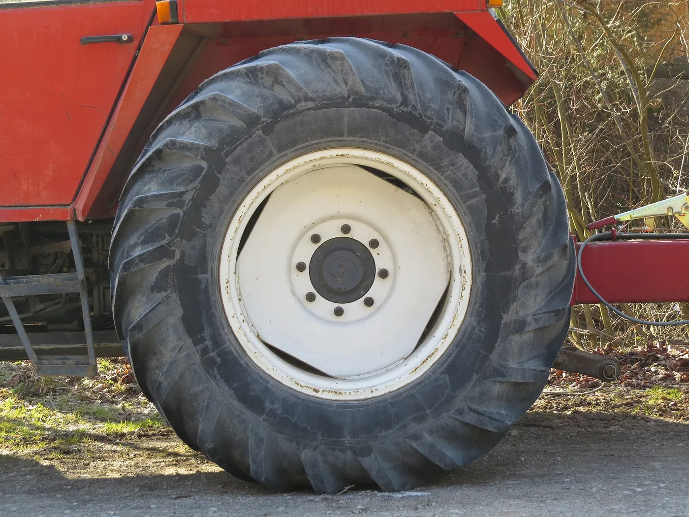 Roue arrière de tracteur avec son pneu agricole à barrettes et sa jante blanche