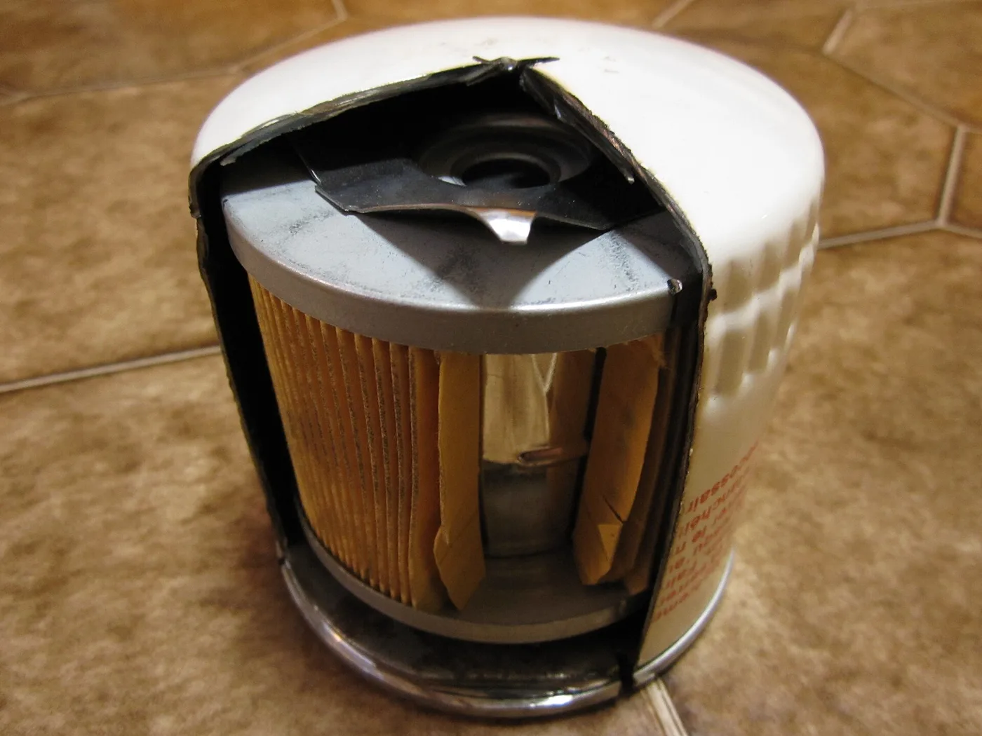 Filtre à huile moteur coupé montrant l'élément filtrant en papier plissé