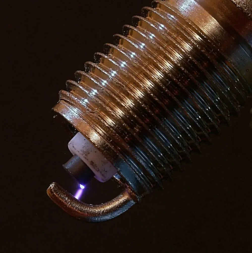 Culot fileté et électrodes d'une bougie d'allumage avec l'étincelle entre les électrodes