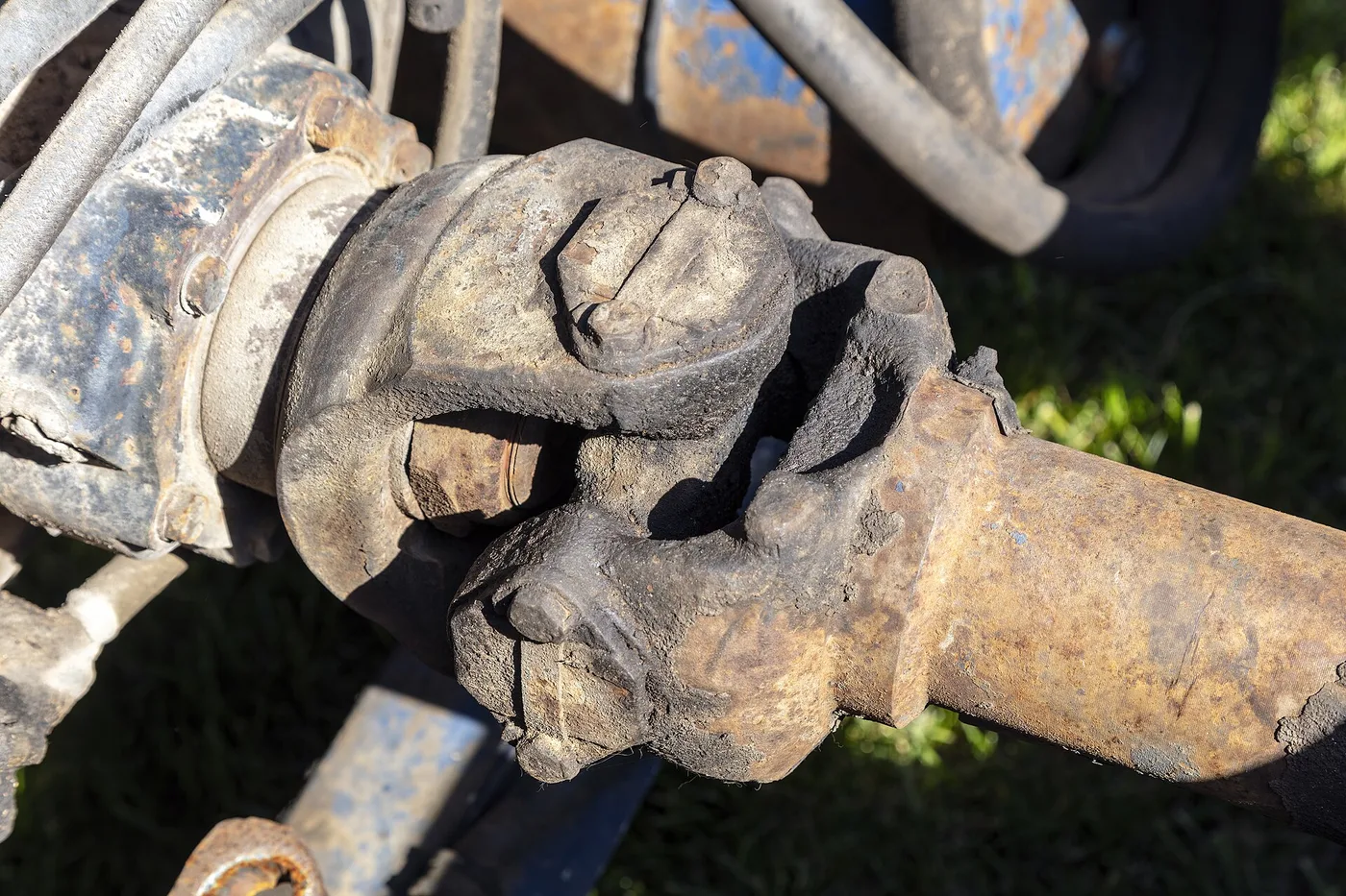 Croisillon de cardan usé et rouillé entre ses deux mâchoires sur un arbre de transmission